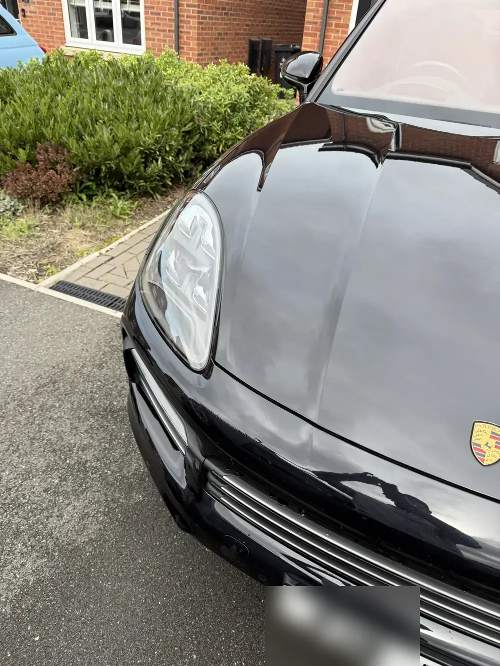 Black Porsche bonnet and headlight with a fresh ceramic coating